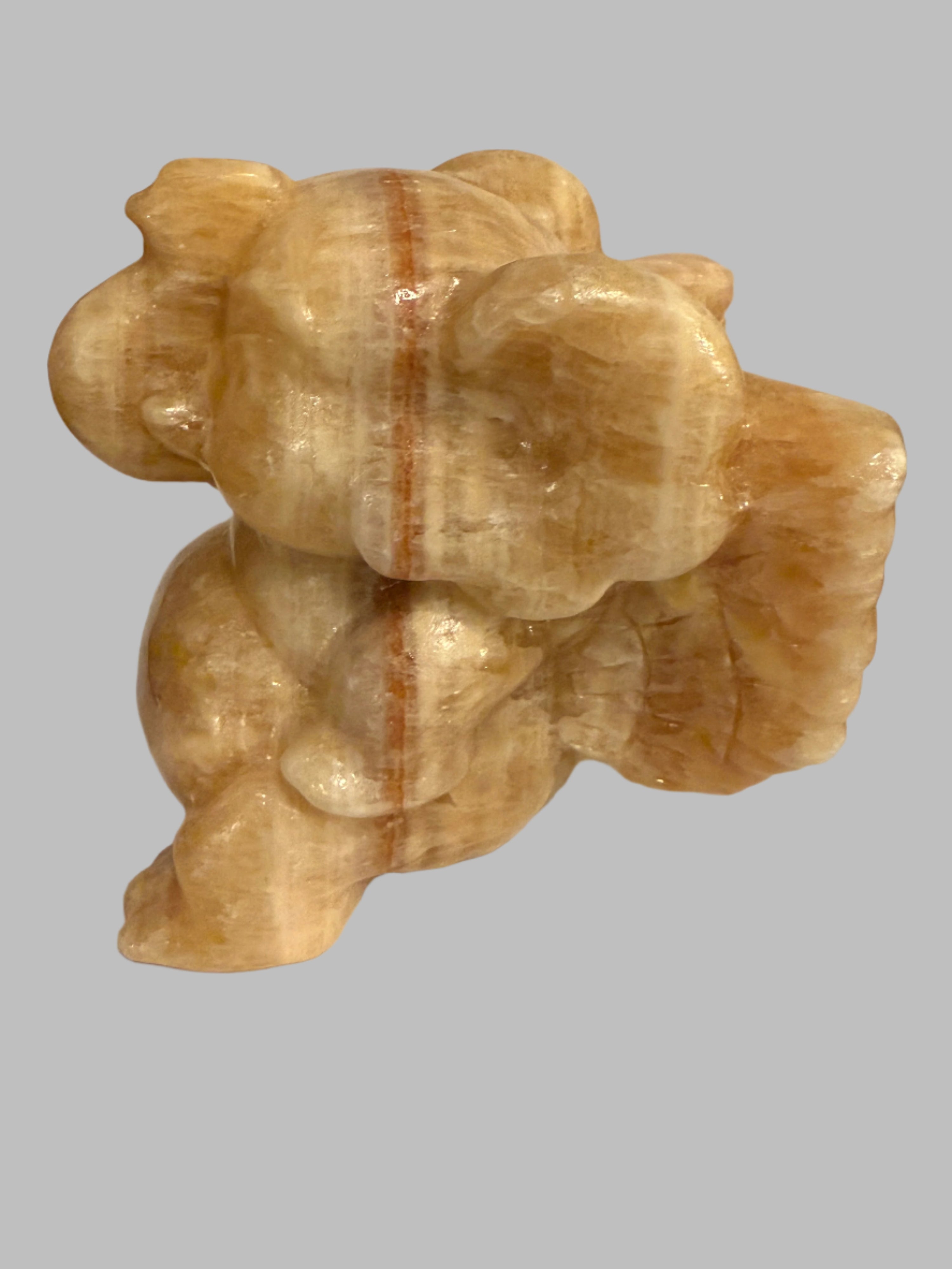 Decorative stone sculpture of a bear on a plain background